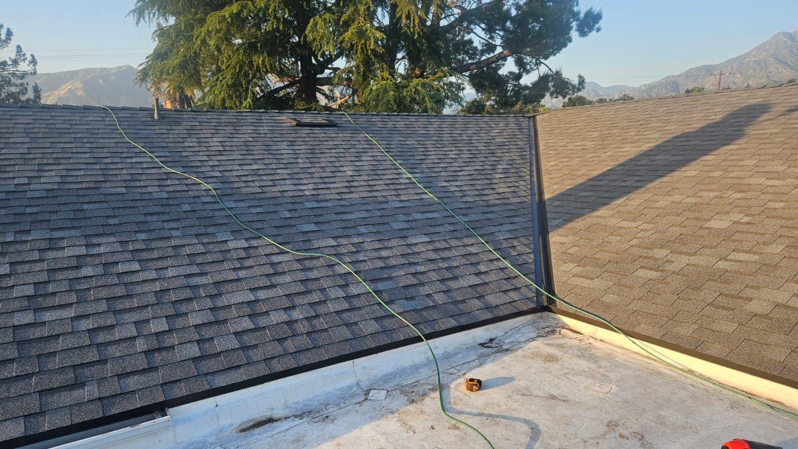 Hillside home with new architectural shingle and a flat roof section by Samuel Roofing Inc. (portfolio photo)