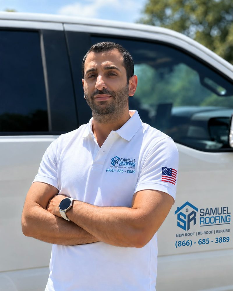 Sam Shmuel, owner of Samuel Roofing Inc., standing in front of his company truck